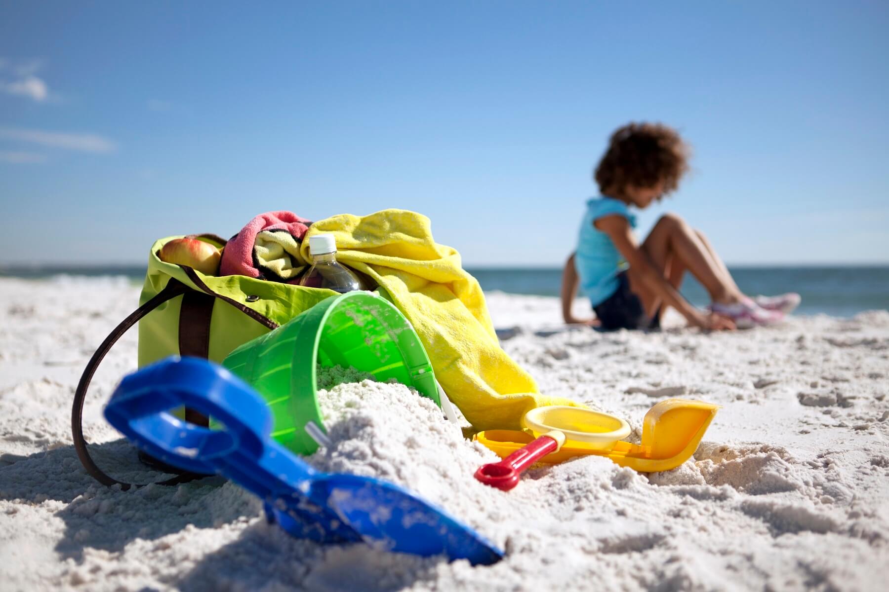 child on beach with toys